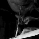 A drug user inhales "Shabu", or methamphetamine, at a drug den in Manila
