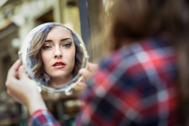 woman-looking-mirror_1139-519