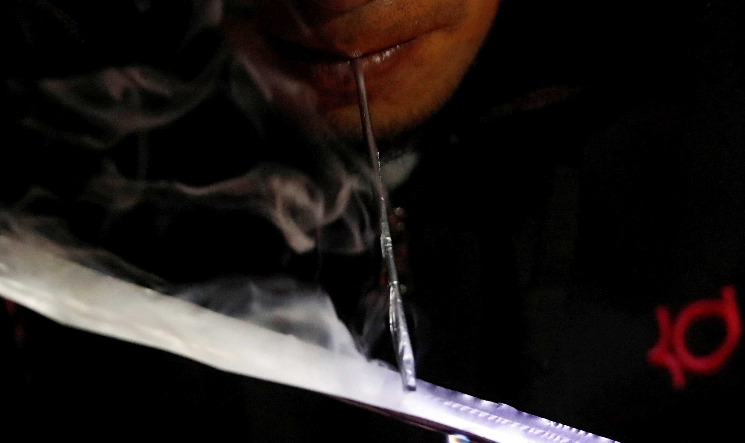 A drug user inhales "Shabu", or methamphetamine, at a drug den in Manila