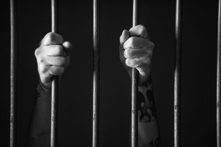 hands-clutching-jail-bars