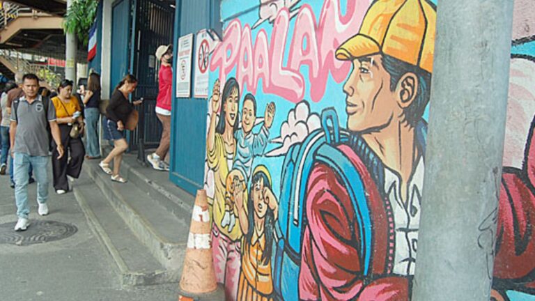 Pedestirans walk past a mural dedicated to Overseas Filipino Workers (OFWs) displayed on the walls of the Department of Migrant Workers in Mandaluyong City on Monday, June 15, 2026. According to t